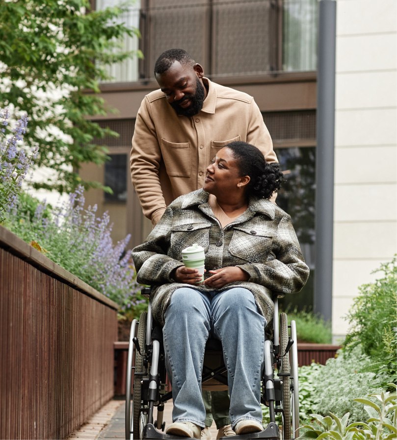 Husband Pushing Wife In Wheel Chair
